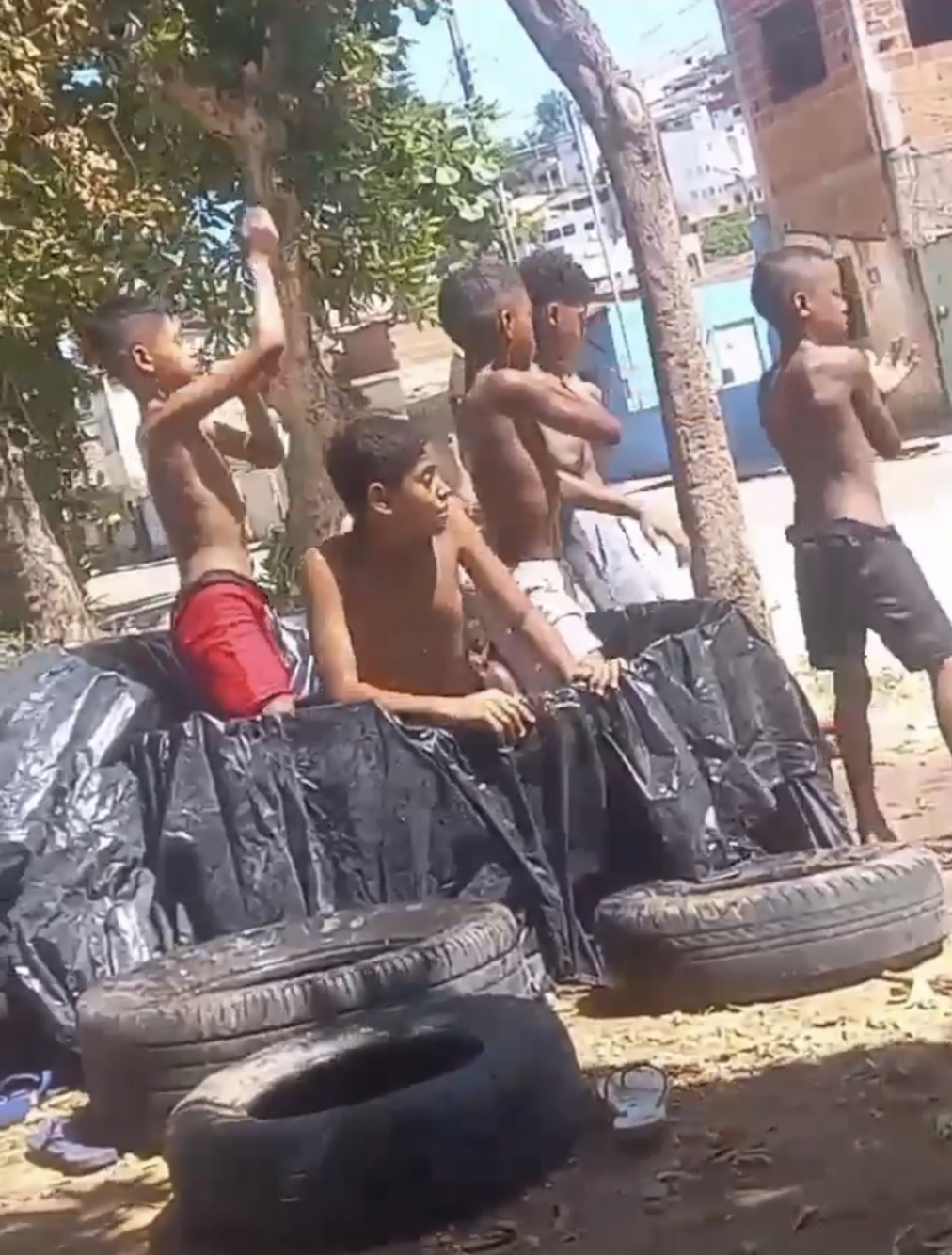 Tá quente aí? Aos 36• crianças improvisam “piscina” de lona em rua no São Jacinto para refrescar, em Teó